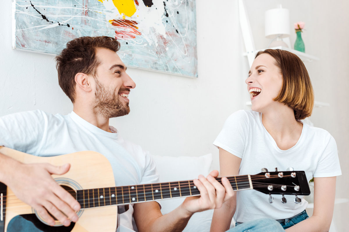 парень и девушка поют под гитару