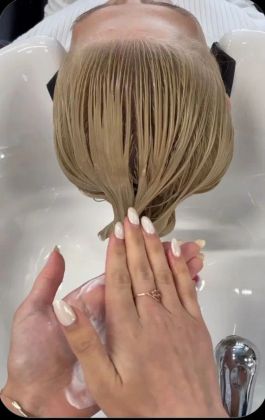 Парикмахер аккуратно стрижет волосы клиента, создавая стильную стрижку