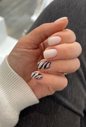 маникюр с белым лаком и черно-белыми полосками зебра на безымянном и мизинце, стильный дизайн ногтей