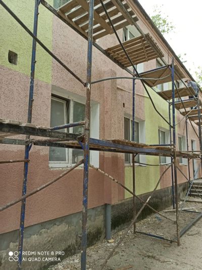 Строительная площадка: леса вдоль кирпичного здания и монтаж конструкций