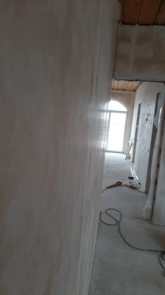 Штукатурка стен в коридоре: аккуратная светлая поверхность в процессе отделки