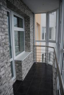 Ремонт четырёхкомнатной квартиры. Балкон облицован гипсовой плиткой под кирпич и керамогранит на полу.