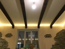 Натяжной потолок со светодиодной подсветкой по периметру в частном доме с декоративными балками
