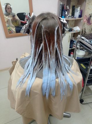 Парикмахер стрижет клиента, создавая стильный образ.