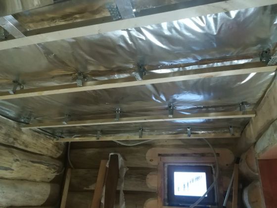 Зашивка потолка фольгированной пароизоляцией и смонтирована обрешетка на подвесы, для выравнивания потолка. У оконного проема сделаны затесы для монтажа откосов и наличников