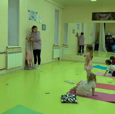 Гимнастки осваивают ритмическую гимнастику в спортивном зале.