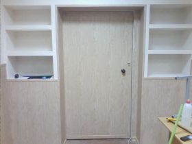 Вокруг входной двери в класс возведён шкаф из ГКЛ, половина обшита МДФ панелями, половина оклеена обоями. Дверь обшита МДФ