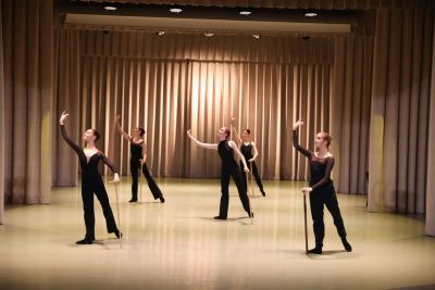 Группа танцоров выполняет синхронную хореографическую постановку.