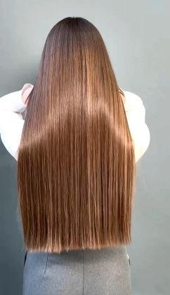 Парикмахер ухаживает за длинными гладкими волосами клиента перед укладкой