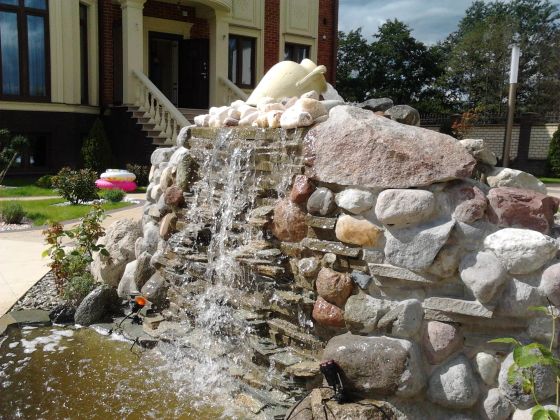 Озеленение и фонтан из натурального камня на частном участке в Калининграде