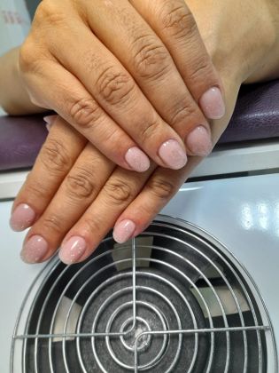 Маникюр с гель-лаком в нежных розовых оттенках с блестками на аккуратных ногтях.