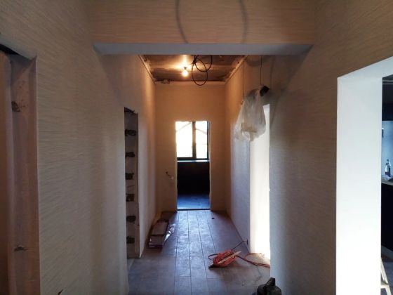 Ремонт коридора в доме (штукатурка стен под шпатель, шпаклевка стен финишем, оклейка стен обоями, укладка ламината, монтаж плинтуса)