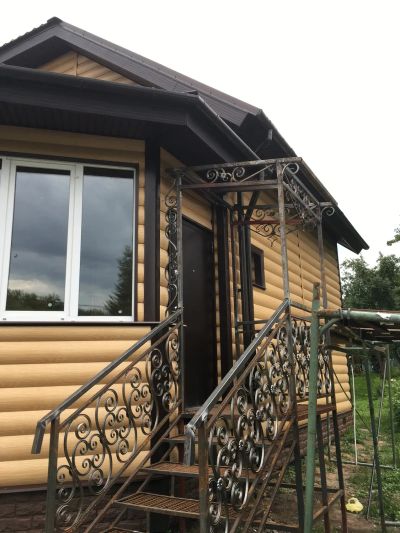 Сайдинг, софиты, крыльцо с коваными элементами 