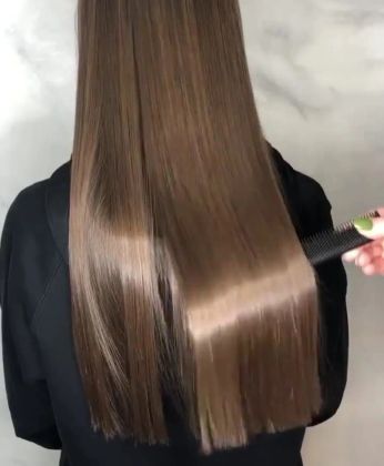 Парикмахер профессионально укладывает и подчеркивает стиль длинных волос.