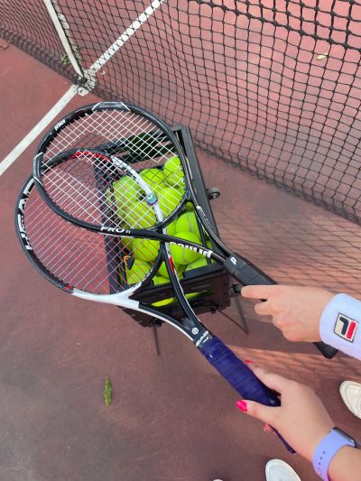 Игрок большого тенниса в ярком костюме выполняет мощный удар по мячу на корте