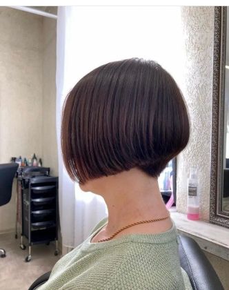 Парикмахер аккуратно подстригает клиента, создавая стильный образ