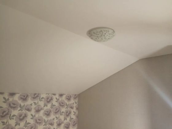 Матовый белый натяжной потолок в помещении мансардного типа