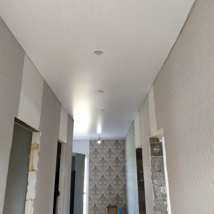 Натяжной потолок белого (матового) цвета, Г-образной формы захватывает кухню и коридор, установка точечных светильников