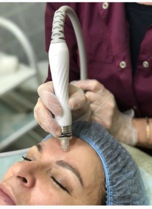 Косметологическая процедура лица с прибором для ухода за кожей