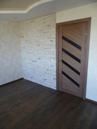 Выравнивание стен, укладка декоративного камня, шпатлевка, обои, ламинат, двухуровневый натяжной потолок, установка межкомнатной двери