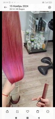 Парикмахер окрашивает волосы в ярко-розовый оттенок.