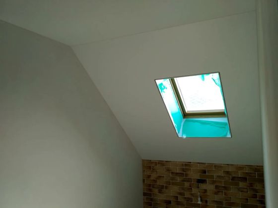 Натяжной потолок в мансардном помещении с оконным проёмом