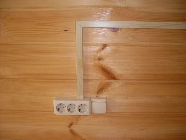 Установка розетки и выключателя в дачном доме, кабель проложен в кабельном канале с имитацией древесины сосны